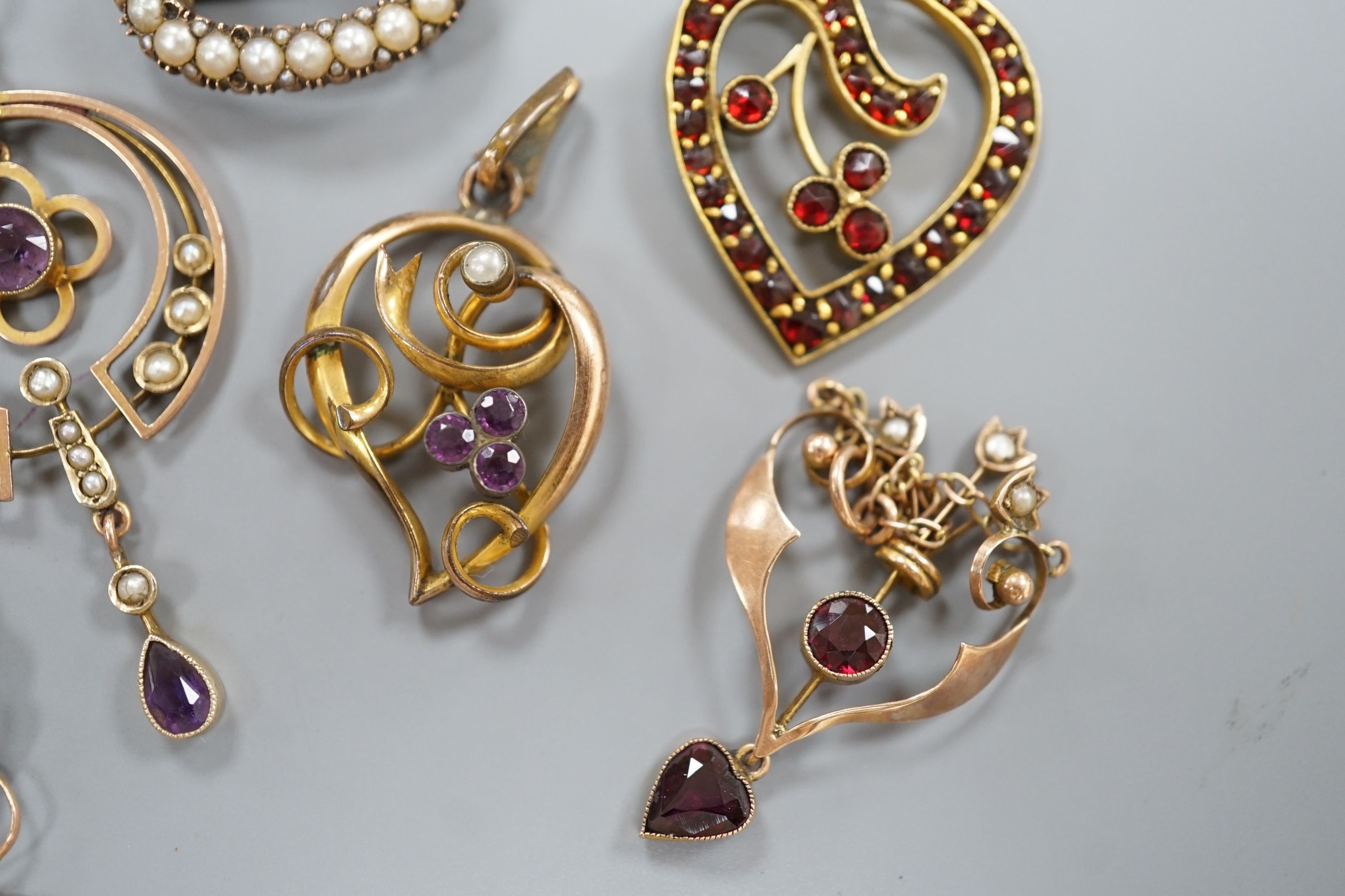 Three early 20th century yellow metal and gem set drop pendants, including two stamped 9ct and two with 9ct chains, largest 5cm, gross weight 10.1 grams, two other pendants and a yellow metal and split pearl set oval bro